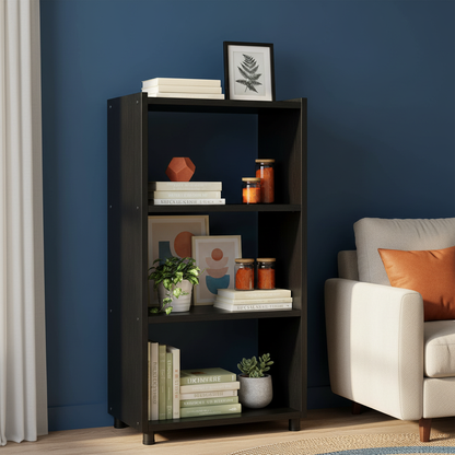 Tall black open shelf styled with books, plants and decorative objects in a colorful living room